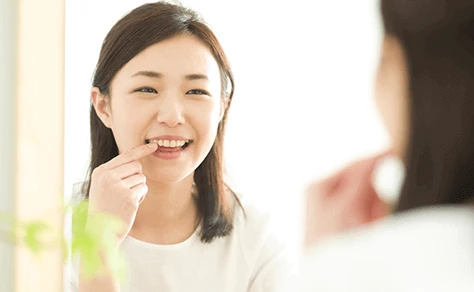 歯の色を確かめる女性の写真